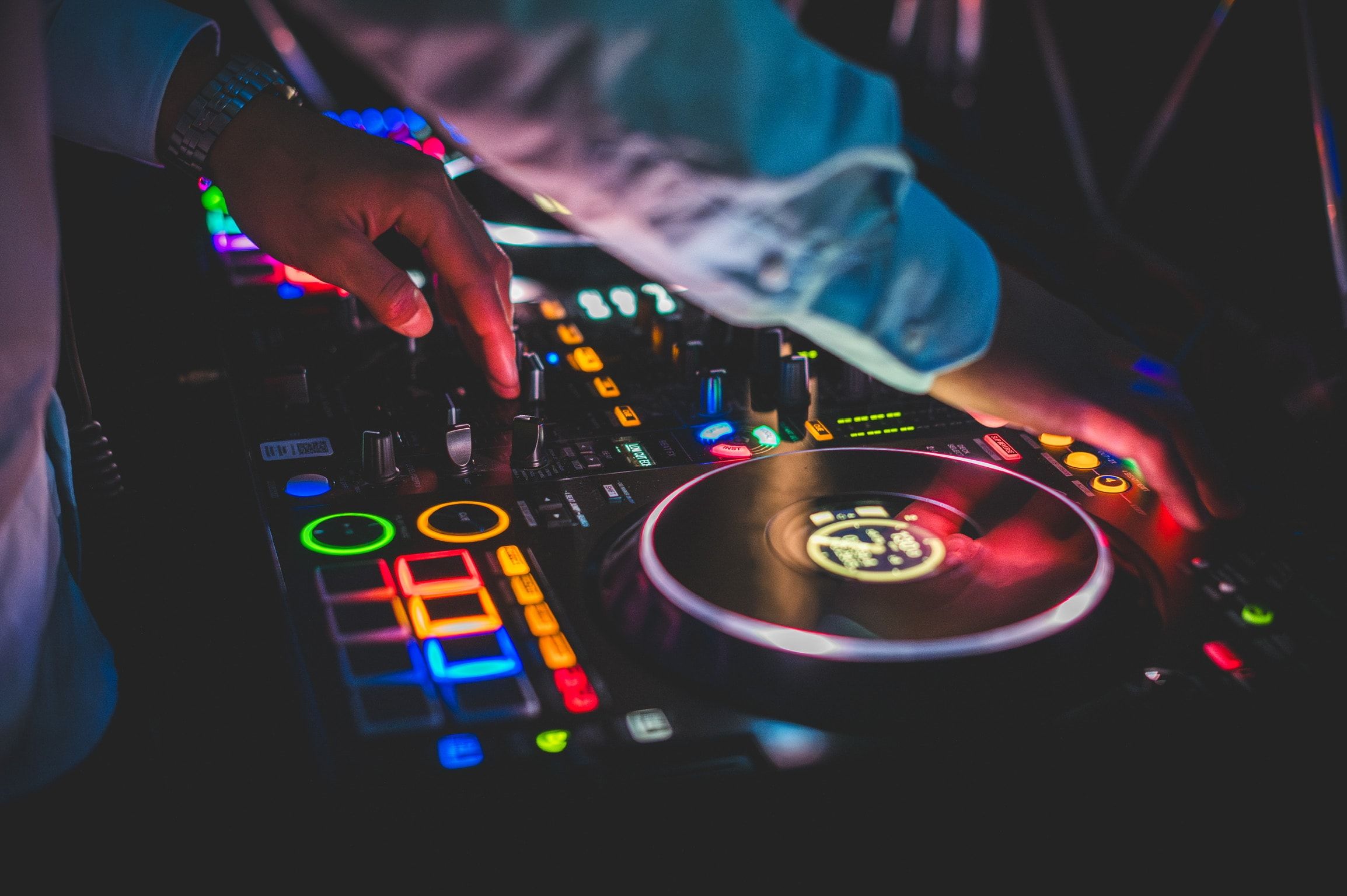 Les mains du DJ sur le contrôleur aux pads lumineux