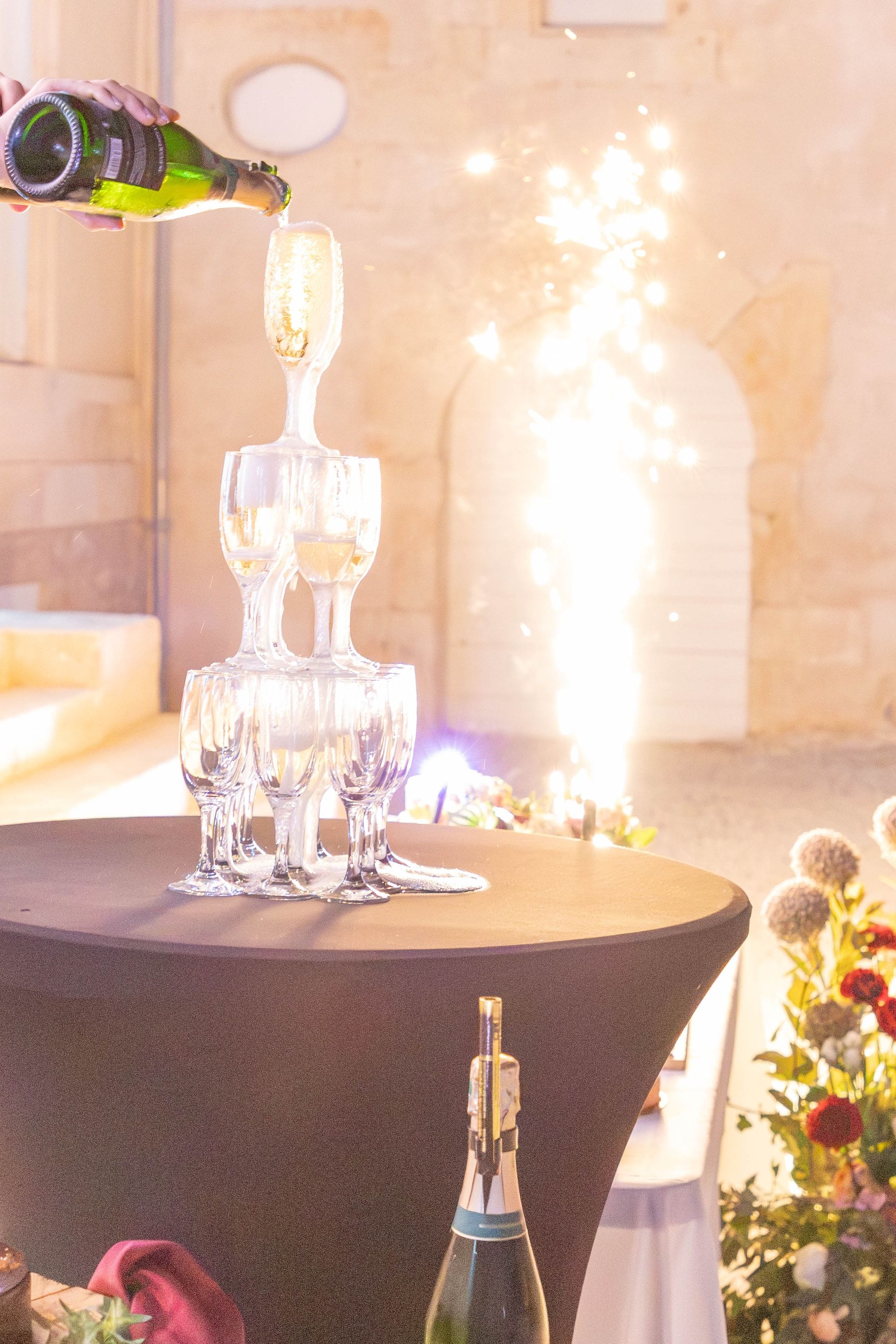 Service d’une pyramide de champagne devant une colonne d’étincelles froides